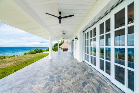 A white patio near dining room, with ceiling fans and full size